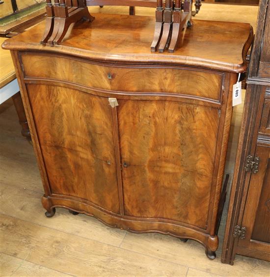 A flame mahogany serpentine fronted two door dwarf cabinet on cabriole legs, with shaped apron and fitted cutlery drawer over W.86cm